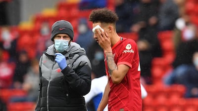 Liverpool's Rhys Williams is helped by medical staff after sustaining an injury. Reuters