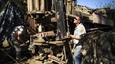 Driller Justin Arney (L) and drill helper Jimmy Payne (R) set up another 20-foot section of pipe as they work to deepen the Brady family well in Woodland, California. Max Whittaker / Reuters
