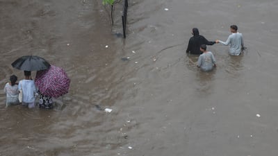 People wade through a flooded streeti. EPA