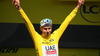 UAE Team Emriates rider Tadej Pogacar celebrates on the podium after maintaining his one minute six seconds general classification lead over second place Remco Evenepoel. AP