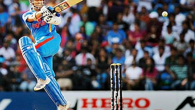 Indian cricketer Sachin Tendulkar holds the trophies after he won the Cricketer of the Year and People's Choice awards at the International Cricket Council Awards.