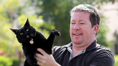 Jon Edwards with cat Smudge at his villa in Al Ghadeer Village in Abu Dhabi. Pawan Singh / The National
