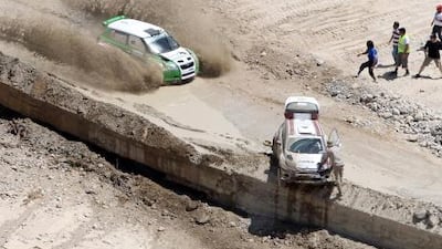 Jordan's Maruf Abu Samra and his co-driver Malek Hariri drive past Qatar’s Khaled al-Suwaidi and his Italian co-driver Nicola Arena at the Jordan Rally. AFP Photo
