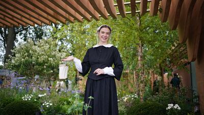 A woman dressed as Florence Nightingale poses in the garden of the same name. PA
