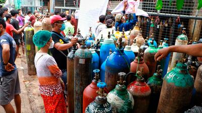 People wait to have oxygen tanks refilled outside the Naing oxygen factory in Yangon, Myanmar. AP