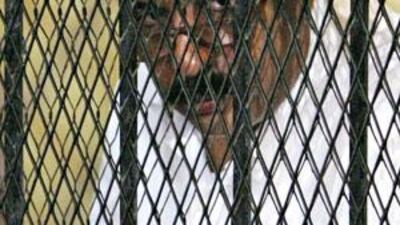 Hisham Talaat Moustafa, the former chairman of the Talaat Moustafa Group, stands behind bars at a court in Cairo yesterday.