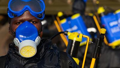 A Uganda People's Defence Force soldier dons protective equipment before spraying crops with pesticide. Getty Images