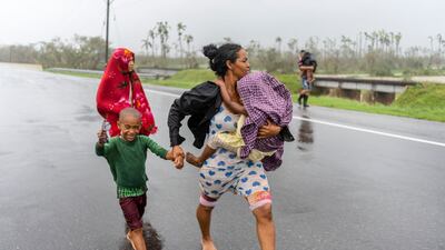 A family walks in the rain after Hurricane Ian hit Pinar del Rio, Cuba. AP