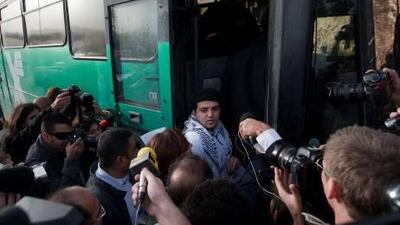 Reporters surround a Palestinian activist as he boards a bus outside the West Bank Jewish settlement of Migron, near Ramallah.