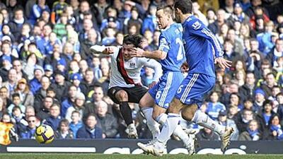 Manchester City's Carlos Tevez, left, scores his side's equaliser to make it 1-1 at Stamford Bridge yesterday.