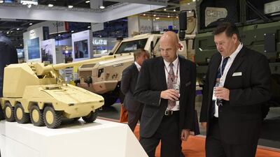 Visitors take a look at one of the model tanks on display at the KMW stand. Ben Pruchnie / Getty Images