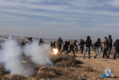 Members of Hilltop Youth, a settler organisation sanctioned in the US and Europe, run for cover during the clashes. AFP