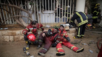 Lebanese firemen rest outside a building that was damaged in a wildfire in the town of Damour, about 15kmsouth of Beirut. AP Photo