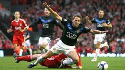 Manchester United's Michael Owen tumbles under a challenge from Liverpool's Jamie Carragher at Anfield on Sunday. Ferguson thought the referee, who waved play on, should have sent Carragher off.