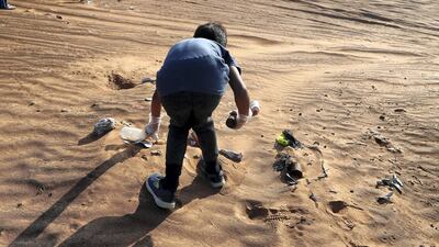 Members collect trash during the desert clean-up drive.