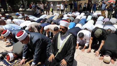 Palestinians pray as Israeli police officers look on by newly installed metal detectors at an entrance to the compound known to Muslims as Noble Sanctuary and to Jews as Temple Mount in Jerusalem's Old City. Ammar Awad / Reuters