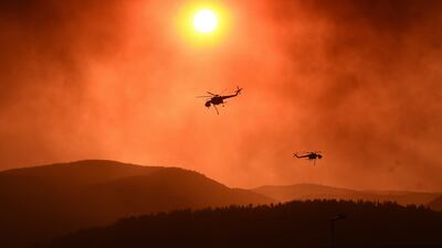 Helicopters fight wildfires in Greece in August. Britain has published a white paper on using international development aid to tackle climate change fallout and extreme povery. AFP
