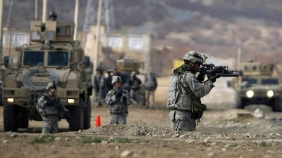 US soldiers keep watch at the scene of a suicide car bomb attack in Parwan province.