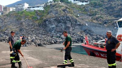 Firefighters sweep up ash in the village of Ginostra, on the small Sicilian island of Stromboli, southern Italy, a day after the Stromboli volcano erupted. Civil protection authorities said a hiker was killed during the eruptionswhich sent about 30 tourists jumping into the sea for safety. AP