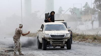 Fighters drive past the spot where a mortar had just hit during clashes. AFP