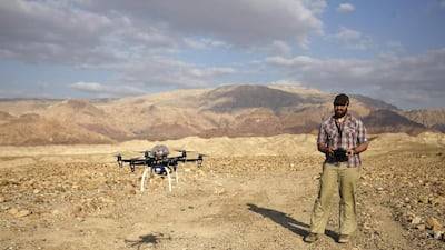 Chad Hill, an archaeologist at the University of Connecticut, operates a drone to survey looting at a 5,000-year-old cemetery known as Fifa in southern Jordan. Mr Hill to take photographs of how looting has altered the landscape. Sam McNeil/AP Photo