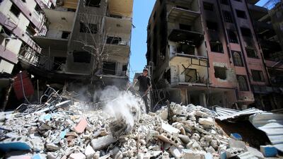 A boy stands on the rubble of damaged buildings in the city of Douma, near the Syrian capital Damascus. Ali Hashisho / Reuters