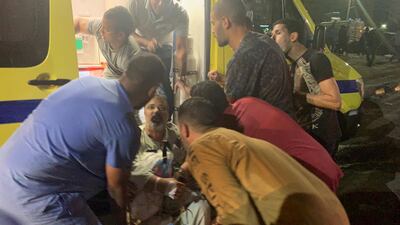 People tend to an injured man after a blast outside the National Cancer Institute, Cairo, Egypt. EPA