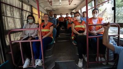 A group of doctors and nurses take the bus home after a long day at work.