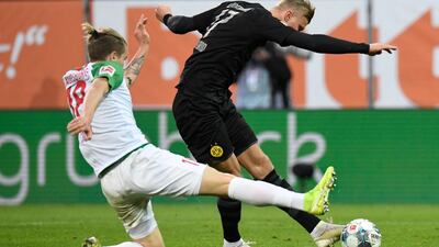 Dortmund forward Erling Braut Haaland (R) scores past Augsburg's defender Tin Jedvaj. AFP