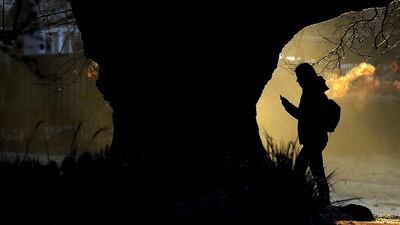 A man walks through a park as the sun rises in London. A fog warning has been issued across parts of the country, with temperatures dropping across the capital. Frank Augstein / AP