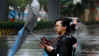A woman struggles against gusts of wind generated by Typhoon Mitag in Taipei, Taiwan. Fast-moving Typhoon Mitag was bearing down on northern Taiwan on Monday, bringing high winds and heavy rain and forcing flight cancellations. AP Photo
