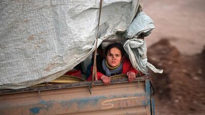 A displaced Syrian girl rides in the back of a truck on the way to Deir al-Ballut camp in Afrin's countryside along the border with Turkey. AFP