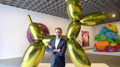 Artist Jeff Koons poses next to one of his sculptures at “eff Koons: A Retrospective, an exhibition of his work at the Whitney Museum of American Art in New York. (AFP / Timothy A. Clary)