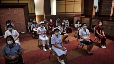 Health workers wait to receive the CoronaVac vaccine, developed by China’s Sinovac firm, as the first batch of vaccines are administered to frontline health workers at the Bamrasnaradura Infectious Diseases Institute in Bangkok. EPA