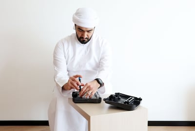 Omar Al Hashmi works on restoring an old gaming console, part of his collection of more than 50 machines. Chris Whiteoak / The National