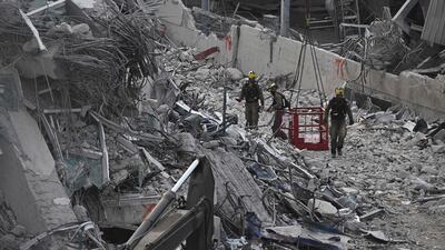 Rescuers sent by Israel as part of an international assistance effort survey the site of building under construction that collapsed due to an earthquake in Bangkok, Thailand. AFP