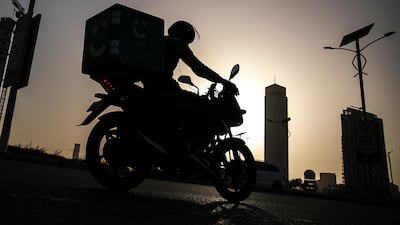 A delivery worker on his motorcycle in Dubai. Pressure not to keep customers waiting is leading to some reckless riding, campaigners say. EPA