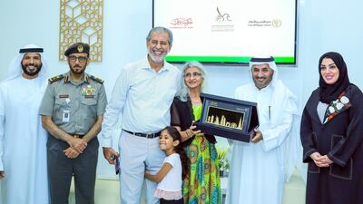 An investor and his family receive the 5-year residency visa in Dubai on Thursday. Courtesy Dubai Land Department