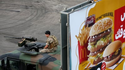 A Lebanese soldier watches anti-government protests in Sidon from atop a military vehicle. Reuters