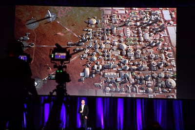 Elon Musk delivers a presentation, with a representation of what he imagines a human colony on mars to look like on the screen behind him, at the International Astronautical Congress in Adelaide, South Australia. Morgan Sette / EPA