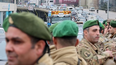 Lebanese soldiers stand guard as taxi drivers block a motorway in Beirut on Tuesday to protest against a rise in petrol prices. EPA