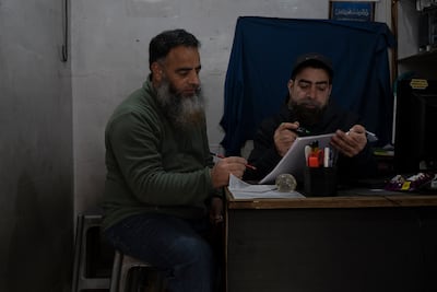 Qasir Shafi Mir, son of Shafi Mohammad Mir, and Waseen Ahmed Mir, son of Abdul Hamid Mir, studying a hard copy of the digitised version of the Quran translated to Hindi. Photo: Wasim Nabi