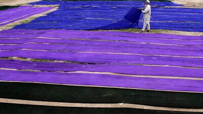 Rahimullah Khan collects fabrics he dyes in Peshawar, Pakistan. Mohammad Sajjad / AP Photo