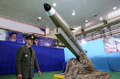 Iran's Defence Minister, Brig Gen Amir Hatami, stands next to a new short-range ballistic missile in August 2018. Iranian Defence Ministry / AFP
