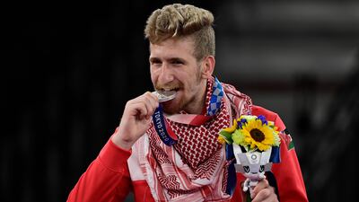 Silver medallist Saleh Elsharabaty of Jordan celebrates on the podium after the taekwondo men's 80kg bouts.