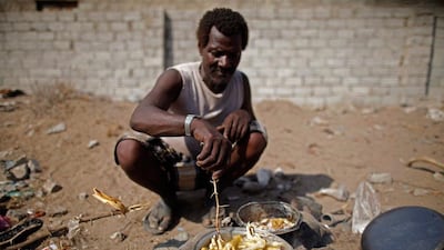 A man from the Akhdam community cooks chicken feet outside his hut in Houdieda.