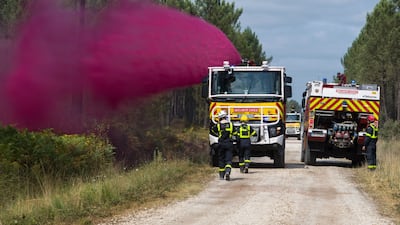 Firefighters spray fire retardant in Le Tuzan. Bloomberg