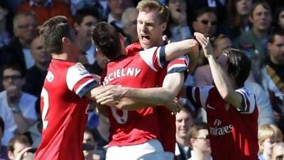Per Mertesacker, right, is mobbed by his Arsenal teammates after he scored the decisive goal on Saturday. Lefteris Pitarakis / AP Photo