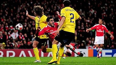 Fabregas, centre, was hurt in winning a penalty in a challenge from Barca's Carles Puyol.