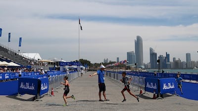 An event marshal guides youngsters on their running leg of the race.